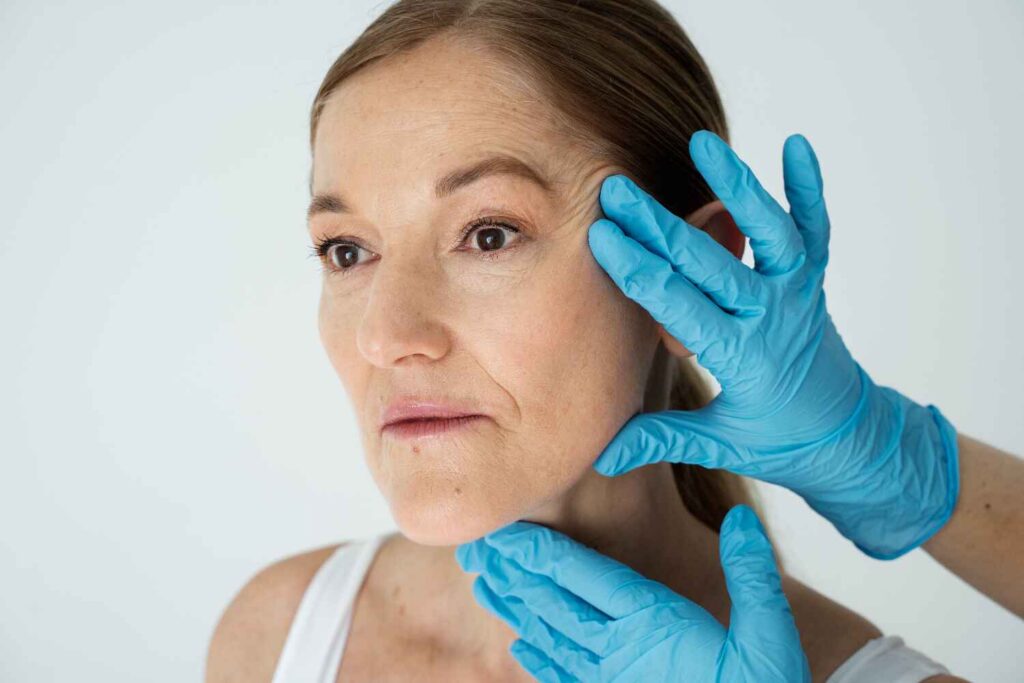 Doctor checking women's face for grafting